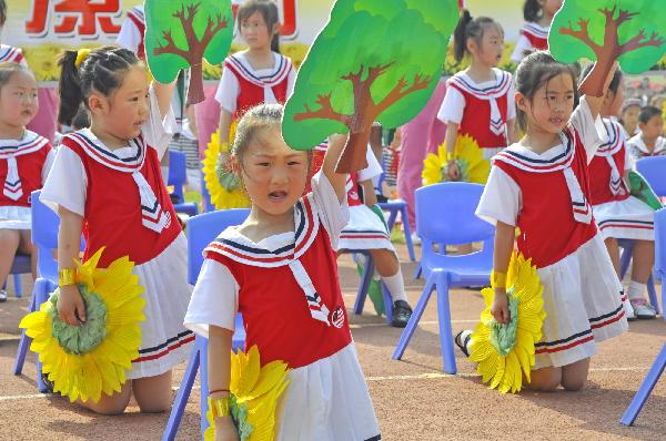 Phalanxes of children take part in a collective loud elocnte of traditional Chinese classical literature, to mark the forthcoming June 1st International Childrens' Day, at the hometown of Xu Shen, a pioneering ancient Chinese dictionary compilor dated back to the Eastern Han Dynasty (25-220), at the Stadium of Luohe City, central China's Henan Province, May 30, 2010.