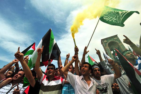 Demonstrators holding flags protest against against an attack by Israeli forces on the international Gaza aid flotilla that has killed 20 people, including Turkish activists,in Istanbul, Turkey, Monday, May 31, 2010. (Xinhua/AFP Photo)