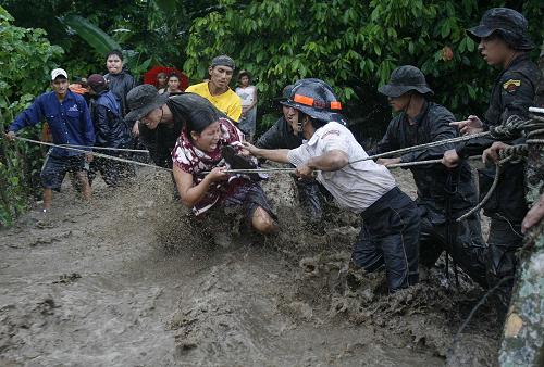 Rescuers help resident evacuating in Izabal City, capital of Izabal Province, Guatemala, May 30, 2010. The death toll caused by storm Agatha in Guatemala has risen to 73, the country&apos;s disaster relief authority spokesman David de Leon said on Sunday. [Xinhua]