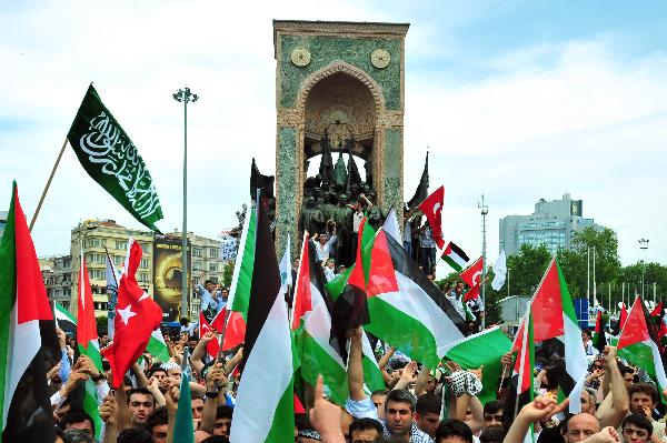 Demonstrators holding flags protest against against an attack by Israeli forces on the international Gaza aid flotilla that has killed 20 people, including Turkish activists, in Istanbul, Turkey, Monday, May 31, 2010. [Xinhua]