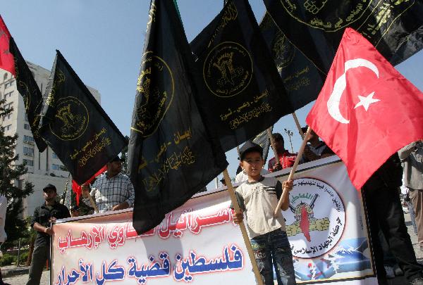 A Palestinian boy holds a Turkish flag during a protest against Isreali navy&apos;s attack in Gaza, May 31, 2010. Up to 19 civilians were killed on Monday in the deadly showdown between Israeli navy and pro- Palestinian activists onboard the Gaza-bound aid flotilla. [Xinhua]