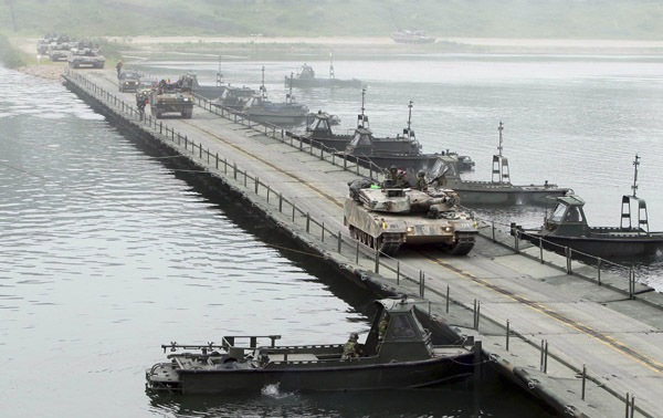 South Korean Army tanks cross a river during their river-crossing exercise in preparation against possible DPR Korean hostilities on the Bukhan river in Hwacheon, about 20 km (12 miles) south of the demilitarized zone separating the two Koreas, northeast of Seoul, May 31, 2010. [Xinhua/Reuters]