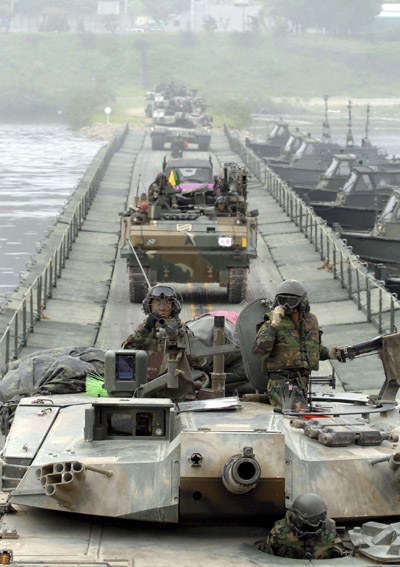 South Korean Army tanks cross a river during their river-crossing exercise in preparation against possible DPR Korean hostilities on the Bukhan river in Hwacheon, about 20 km (12 miles) south of the demilitarized zone separating the two Koreas, northeast of Seoul, May 31, 2010. [Xinhua/Reuters]