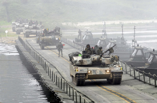 South Korean Army tanks cross a river during their river-crossing exercise in preparation against possible DPR Korean hostilities on the Bukhan river in Hwacheon, about 20 km (12 miles) south of the demilitarized zone separating the two Koreas, northeast of Seoul, May 31, 2010. [Xinhua/Reuters]