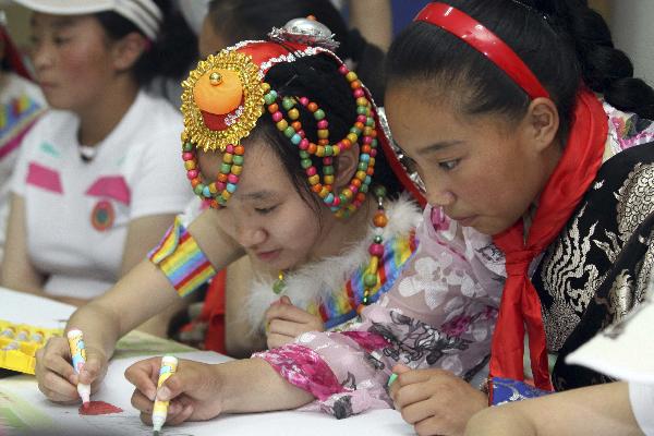 Daixi Qiuzhan (R) from northwest China's quake-hit Yushu Prefecture draws picutre with Wang Shiran of Tianjin at the youth activity center of Tianjin, north China, May 30, 2010. 