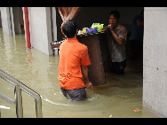 Shop assistants remove property from a low-lying shop in the flood-hit Donglan county, Guangxi Zhuang autonomous region, on June 1. The county was ravaged by flash floods, which caused landslides and blocked roads, with a maximum rainfall of 100 mm, leaving many shops and residences affected. The local government was rallying relief efforts for the disaster. [Xinhua]