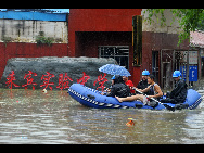 Rescuers using a lifeboat to rescue students trapped at the flooded campus of Laibin City Experimental Middle School in Laibin, southwest China's Guangxi Zhuang Autonomous Region, June 1, 2010. [Xinhua]