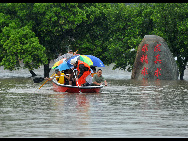 Rescuers using a lifeboat to rescue students trapped at the flooded campus of Laibin City Experimental Middle School in Laibin, southwest China's Guangxi Zhuang Autonomous Region, June 1, 2010. [Xinhua]