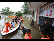 Rescuers transfer the students by lifeboat who are trapped at school in Laibin City, south China's Guangxi Zhuang Autonomous Region, June 1, 2010, due to the continuing severe rain and storm. [Xinhua]