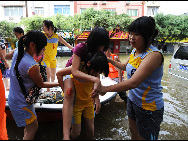 Rescuers transfer the students by lifeboat who are trapped at school in Laibin City, south China's Guangxi Zhuang Autonomous Region, June 1, 2010, due to the continuing severe rain and storm. [Xinhua]