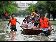 Rescuers transfer the students by lifeboat who are trapped at school in Laibin City, south China's Guangxi Zhuang Autonomous Region, June 1, 2010, due to the continuing severe rain and storm. [Xinhua]