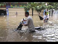 A man walks in flood in Laibin City, south China's Guangxi Zhuang Autonomous Region, June 1, 2010, due to the continuing severe rain and storm. [Xinhua]