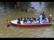 Rescuers transfer the students by lifeboat who are trapped at school in Laibin City, south China's Guangxi Zhuang Autonomous Region, June 1, 2010, due to the continuing severe rain and storm. [Xinhua]