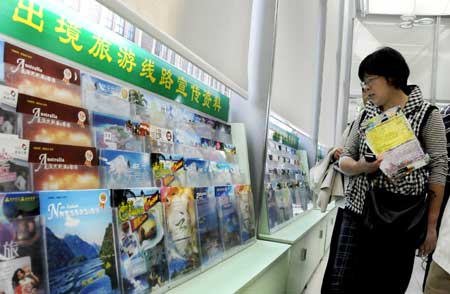 A citizen browses the packages on offer in a travel agency in Shanghai. Photo: IC 