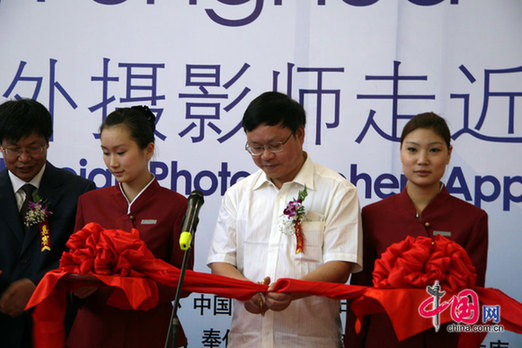  Li Fugen, vice director of China Internet Information Center, cuts the ribbon at the opening ceremony for the 'Charming Fenghua, Hopeful City' photo exhibition.