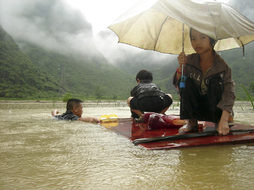 Students are evacuated to safety after flood caused by heavy rain in Hechi, Southwest China&apos;s Guangxi Zhuang autonomous region, June 1, 2010. [Xinhua] 