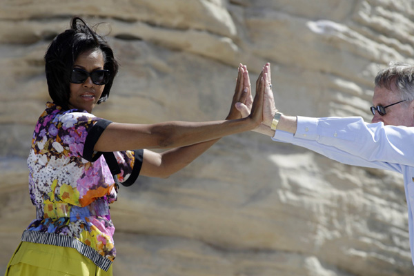 First Lady Michelle Obama (L) and Senate Majority Leader Harry Reid (D-Nev.) stretch during an exercise activity at the Red Rock Canyon National Conservation Area near Las Vegas, Nevada June 1, 2010. [Xinhua/Reuters]