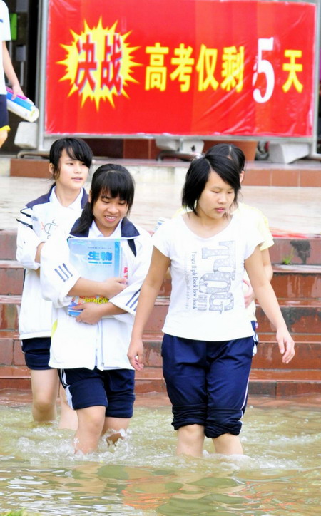 Graduating high school students walk on the flooded campus of the No 2 High School in Du&apos;an county in South China&apos;s Guangxi Zhuang autonomous region, June 2, 2010.