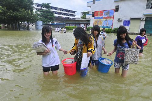 Graduating high school students walk on flooded school campus at the No 2 High School in Du&apos;an county in South China&apos;s Guangxi Zhuang autonomous region, June 2, 2010. The big falls on June 7. [Xinhua]