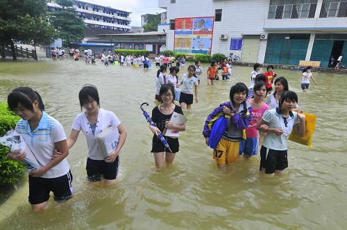 Graduating high school students walk on flooded school campus at the No 2 High School in Du&apos;an county in South China&apos;s Guangxi Zhuang autonomous region, June 2, 2010. The big falls on June 7. [Xinhua]