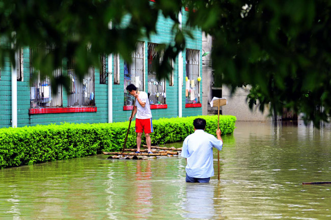 Local residents are seen in flooded street in Yao Ethnic Autonomous County of Du&apos;an in south China&apos;s Guangxi Zhuang Autonomous Region, June 2, 2010. The rainstorms had damaged 3,260 homes and 103,450 hectares of crops, according to Guangxi&apos;s Civil Affairs Department.[Xinhua]