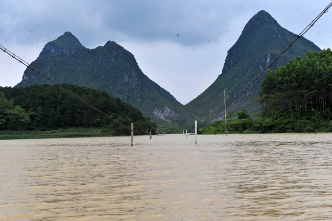 The street is flooded in Shanglang Village of Gupeng Township in Xincheng County in south China&apos;s Guangxi Zhuang Autonomous Region, June 2, 2010. [Xinhua]