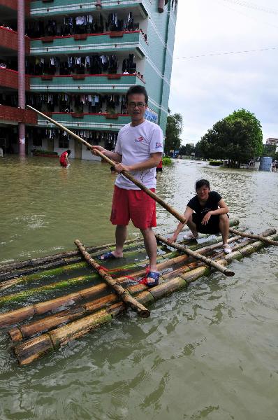 Local residents take raft in flooded Yao Ethnic Autonomous County of Du'an in south China's Guangxi Zhuang Autonomous Region, June 2, 2010. [Xinhua]