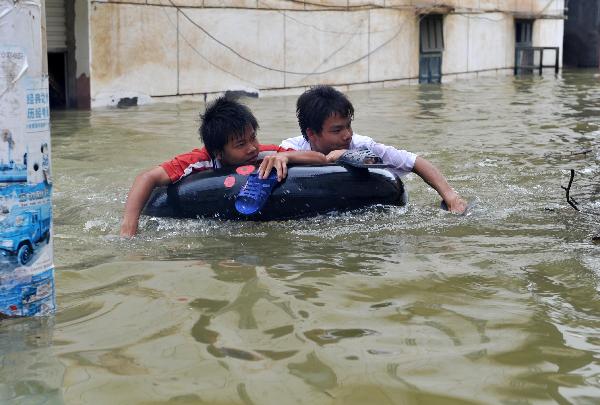 Local residents are seen in flooded Beigeng Township of Xincheng County in south China's Guangxi Zhuang Autonomous Region, June 2, 2010.[Xinhua]