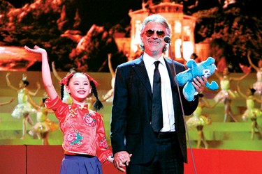 Italian singer Andrea Bocelli (R) hand in hand with a girl from Little Companion Art Troupe during the performance of opening ceremony for the Shanghai World Expo.