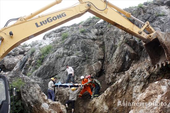 Rescuers carry the woman off the quarry with a stretcher in in Jiujiang, South China's Jiangxi province, June 1, 2010. [Photo/Asianewsphoto]