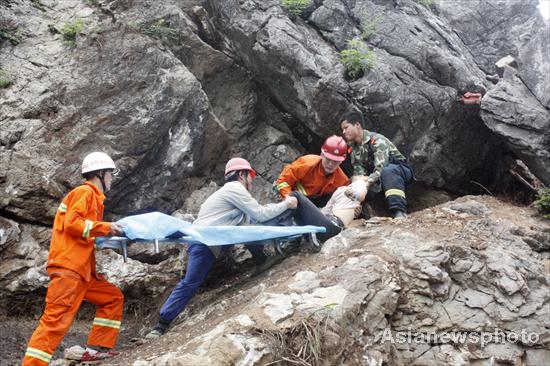 Rescuers pull the women out from the crack, who is stuck between two big rocks after the collapse of a quarry in Jiujiang, South China's Jiangxi province, June 1, 2010. [Photo/Asianewsphoto] 