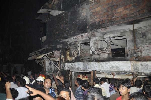 Local residents and fire fighters work at the scene, the aftermath of a devastating fire in Dhaka, capital of Bangladesh, early June 4, 2010. At least 87 people were killed and over 100 injured in the devastating fire that broke out late Thursday in a chemical factory in Dhaka. [Cheng Zhang/Xinhua]