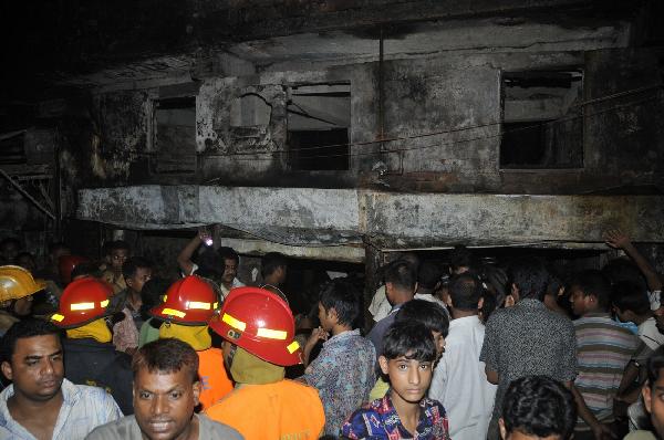 Local residents and fire fighters work at the scene after a devastating fire in Dhaka, capital of Bangladesh, early June 4, 2010. At least 87 people were killed and over 100 injured in the devastating fire that broke out late Thursday in a chemical factory in Dhaka. [Cheng Zhang/Xinhua]