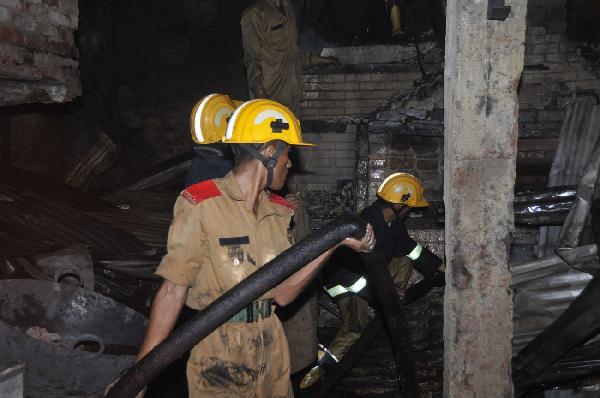 Fire fighters work at the scene after a devastating fire in Dhaka, capital of Bangladesh, early June 4, 2010. At least 87 people were killed and over 100 injured in the devastating fire that broke out late Thursday in a chemical factory in Dhaka. [Cheng Zhang/Xinhua]