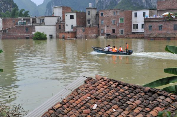 Rescuers search for trapped persons in Beigeng Township, Xincheng County, south China's Guangxi Zhuang Autonomous Region, June 3, 2010. The flood triggered by heavy rain since Wednesday in Guangxi killed 38 people as of Thursday, according to local authorities. Across Guangxi, the rainstorms had battered 27 counties and nearly 80,000 people had been evacuated as of Wednesday night, the local government said. [Xinhua]