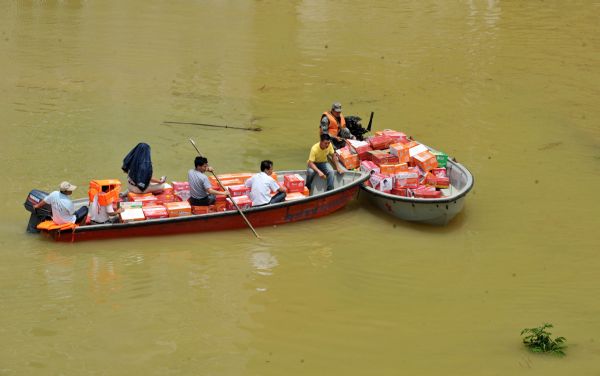 Boats transport relief supplies in Beigeng Township, Xincheng County, south China's Guangxi Zhuang Autonomous Region, June 3, 2010. The flood triggered by heavy rain since Wednesday in Guangxi killed 38 people as of Thursday, according to local authorities. Across Guangxi, the rainstorms had battered 27 counties and nearly 80,000 people had been evacuated as of Wednesday night, the local government said. [Xinhua]