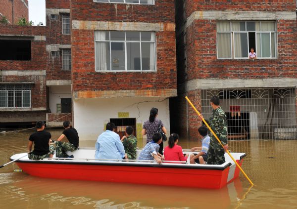 Rescuers search for trapped persons in Beigeng Township, Xincheng County, south China's Guangxi Zhuang Autonomous Region, June 3, 2010. The flood triggered by heavy rain since Wednesday in Guangxi killed 38 people as of Thursday, according to local authorities. Across Guangxi, the rainstorms had battered 27 counties and nearly 80,000 people had been evacuated as of Wednesday night, the local government said. [Xinhua]