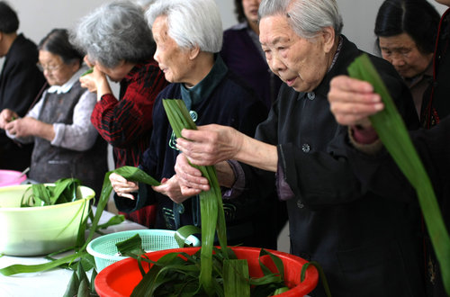 Octogenarians compete to wrap zongzi, a traditional Chinese food made of glutinous rice folded into bamboo leaves and used to celebrate the Dragon Boat Festival that falls on the fifth day of the fifth month on Chinese lunar calendar, in Nantong, East China's Jiangsu province, June 2, 2010.[