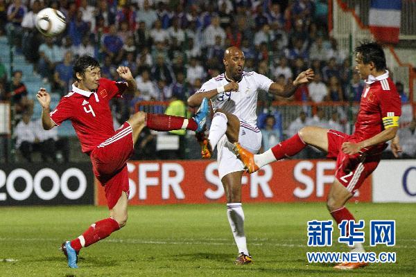 France's national soccer team player struggles with China's players during their friendly soccer match at Michel Volnay stadium on the French overseas territory of La Reunion June 4, 2010.