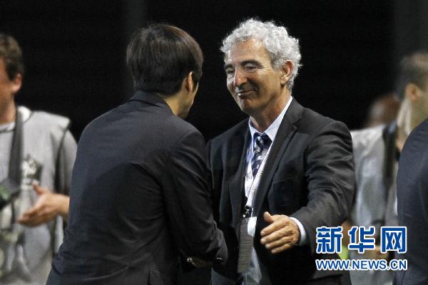 China's team coach Gao Hongbo (L) is congratulated by France's coach Raymond Domenech after China defeated France in a friendly soccer match at Michel Volnay stadium in the French overseas territory of La Reunion June 4, 2010.