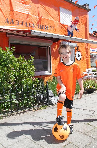 This photo taken on June 4, 2010 shows a young supporter of the Netherlands team poses before an orange decorated house in the Irenestraat street of Goirle in the Netherlands to cheer up the Dutch's national team before the World Cup 2010. Orange is the color of the Dutch national soccer team. [Pan Zhi/Xinhua]