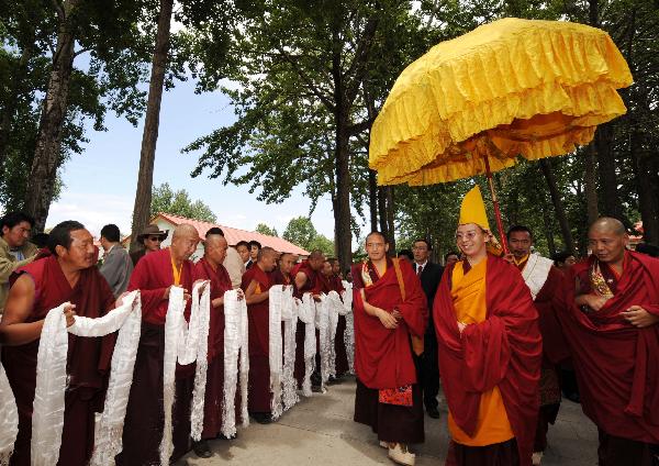 The 11th Panchen Lama(2nd R) greets monks upon his arrival in Lhasa, capital of southwest China&apos;s Tibet Autonomous Region, June 4, 2010. The 11th Panchen Lama arrived at Lhasa for Buddhist activities as an annual routine in recent years.[Chogo/Xinhua]