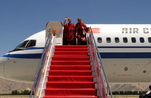 The 11th Panchen Lama(L) waves upon his arrival at the airport in Lhasa, capital of southwest China&apos;s Tibet Autonomous Region, June 4, 2010. The 11th Panchen Lama arrived at Lhasa for Buddhist activities as an annual routine in recent years.[Chogo/Xinhua]