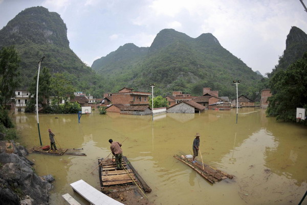 Villagers travel on homemade rafts at a flooded village in Xincheng county, South China’s Guangxi Zhuang Autonomous Region, on June 4, 2010. According to the Guangxi civil authorities, the rains, floods and landslides have affected a total of 3.06 million people in 42 cites and counties in the province, forcing more than 200,000 people to evacuate to safety. [Xinhua]