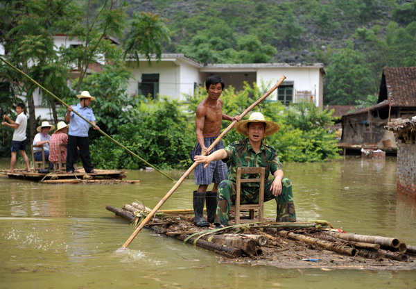 Villagers use rafts at a flooded village in Xincheng county, South China’s Guangxi Zhuang Autonomous Region, on June 4, 2010. [Photo/Xinhua]