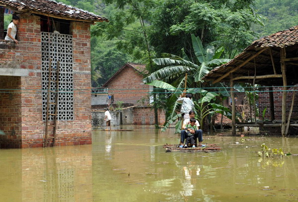 Villagers use rafts at a flooded village in Xincheng county, South China’s Guangxi Zhuang Autonomous Region, on June 4, 2010. [Photo/Xinhua]