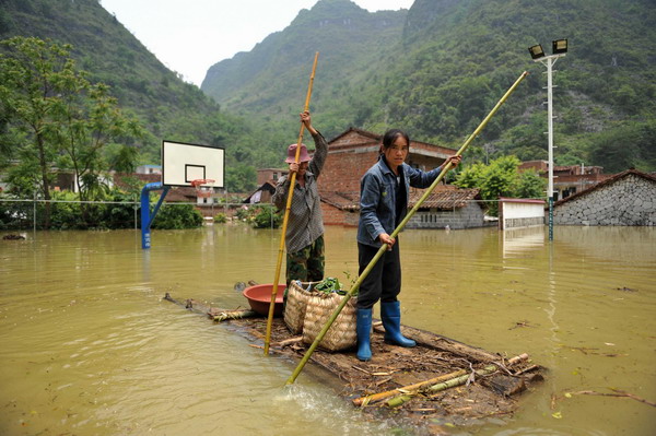 Villagers use rafts at a flooded village in Xincheng county, South China’s Guangxi Zhuang Autonomous Region, on June 4, 2010. [Photo/Xinhua]