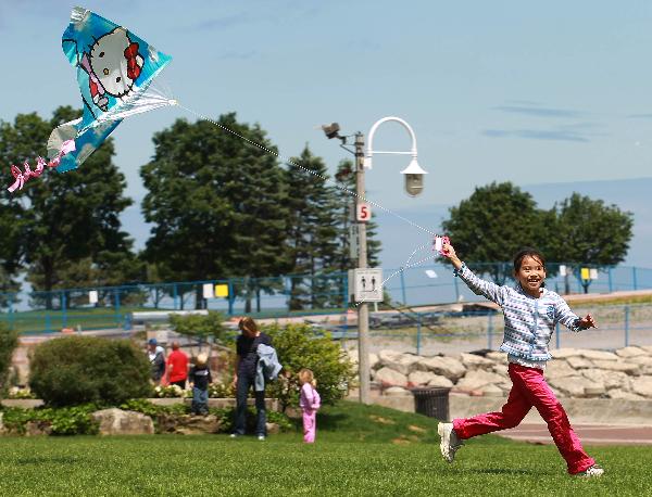 A girl flies a kite during the Children&apos;s Kite Festival in Burlington, Canada, June 6, 2010. [Zou Zheng/Xinhua]