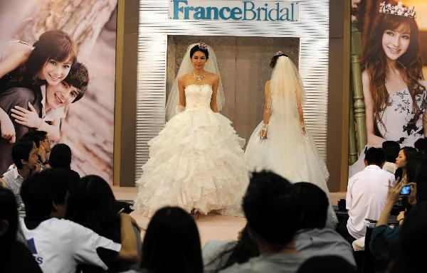 Models display wedding dresses at the Hong Kong Convention and Exhibition Center in Hong Kong on June 6, 2010. The 59th Summer Wedding Service, Banquet and Beauty Expo is held here from June 4 to 6 presenting tens of thousands of wedding dress sorts from 18 countries and regions. 