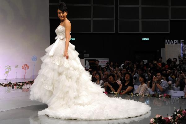 A model displays a wedding dress at the Hong Kong Convention and Exhibition Center in Hong Kong on June 6, 2010. The 59th Summer Wedding Service, Banquet and Beauty Expo is held here from June 4 to 6 presenting tens of thousands of wedding dress sorts from 18 countries and regions. 